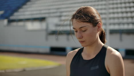 Zeitlupenporträt-Einer-Schönen-Frau,-Die-Auf-Der-Tribüne-Des-Stadions-Läuft,-Mit-Konzentrierter,-Tiefer-Atmung-Und-Motivation-Für-Das-Rennen.-Lassen-Sie-Unnötige-Emotionen-Hinter-Sich-Und-Stimmen-Sie-Sich-Auf-Den-Sieg-Ein,-Während-Sie-Sich-Auf-Das-Rennen-Vorbereiten